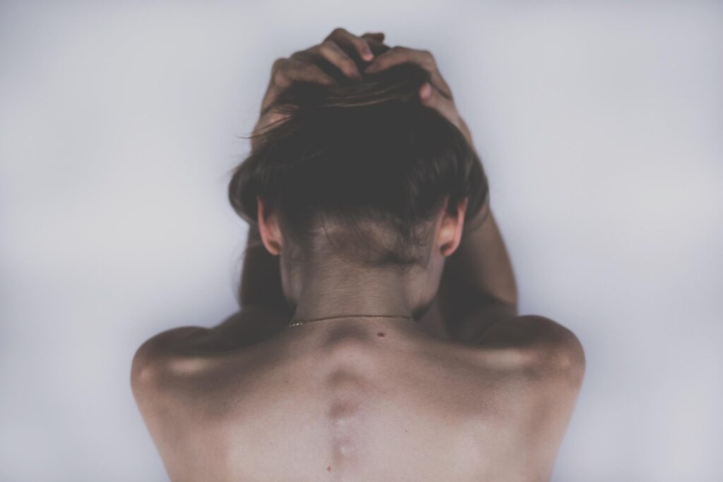 Mujer con la mano en la frente por un dolor de cabeza
