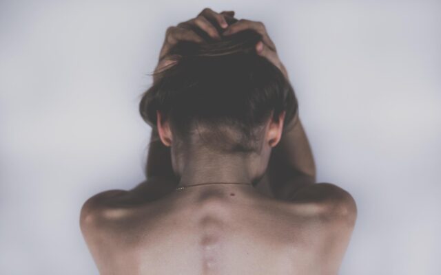 Mujer con la mano en la frente por un dolor de cabeza