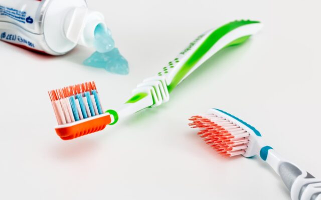 Cepillo de dientes, hilo dental y vaso con agua en el lavamanos